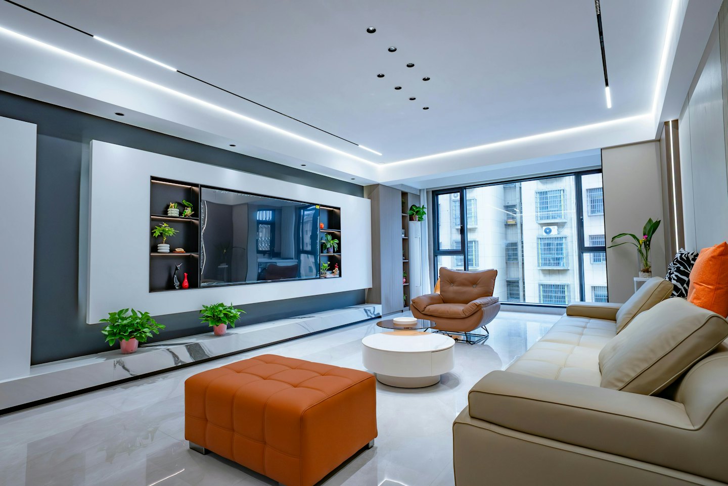 Modern living room with TV, beige sofa, and leather armchair.