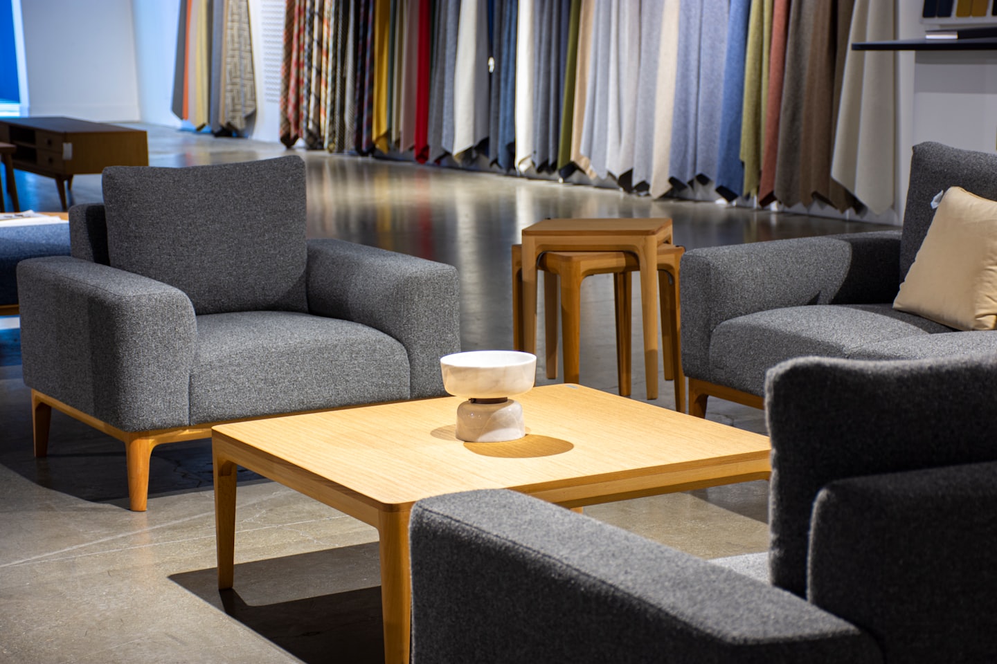 Modern armchairs and a sofa surround a wooden coffee table.