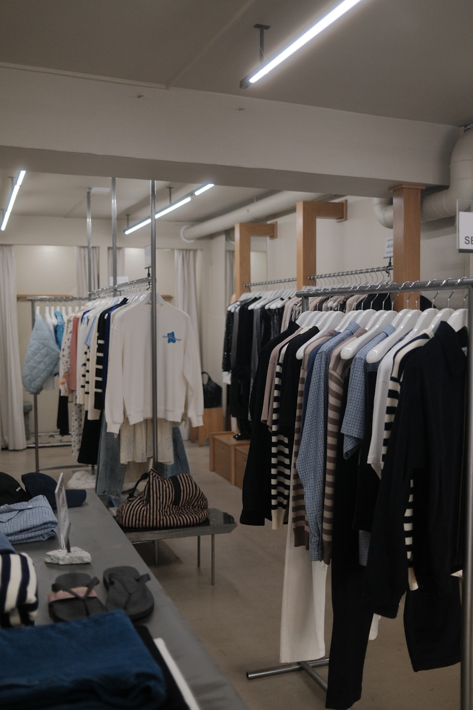 Racks of clothing and accessories displayed in a modern boutique.