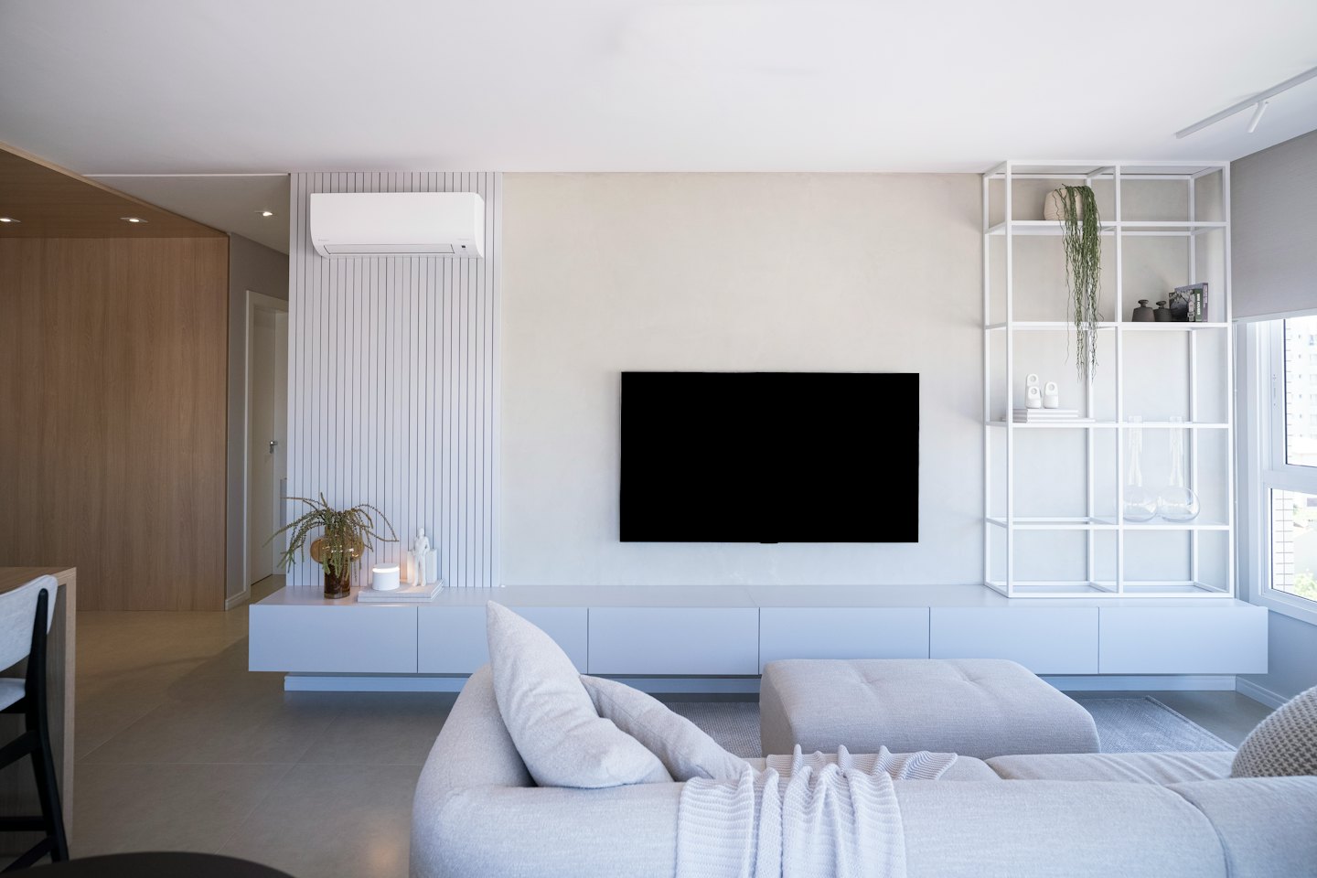 Modern living room with a large TV above a floating entertainment unit.